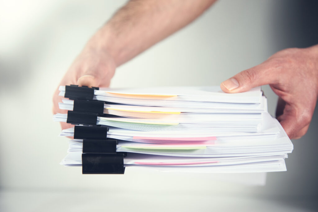 Hands holding a stack of organized papers